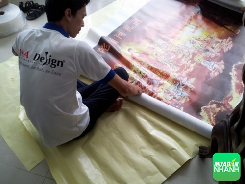 Nhân viên Painting thực hiện gia công thành phẩm tranh in vải silk cho nội thất phòng thờ của khách một cách chuyên tâm và tỉ mỉ